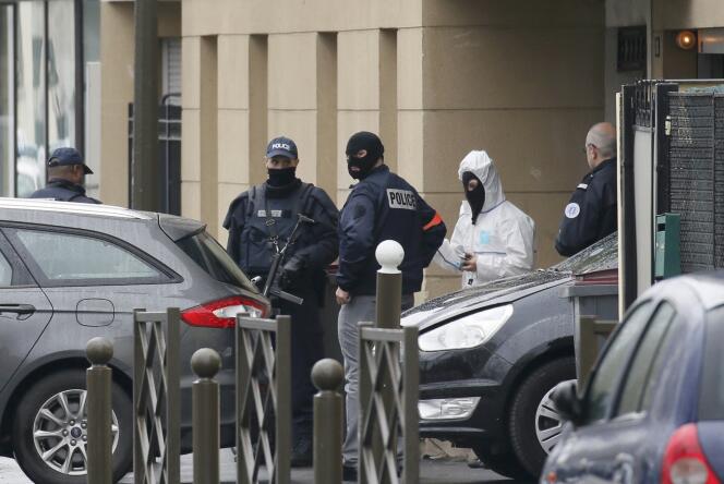 La police française et les experts de la police scientifique, à l'entrée de l'appartement occupé par Reda Kricket à Argenteuil en région parisienne, après l'opération menée le 25 mars 2016 après l'arrestation du suspect.