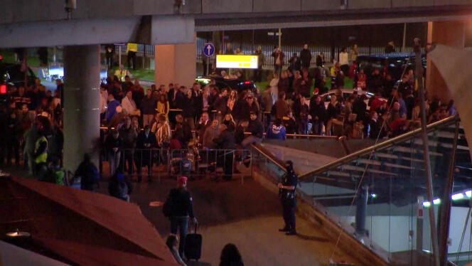 Des passagers attendent devant l'aéroport d'Amsterdam-Schiphol, le 12 avril.