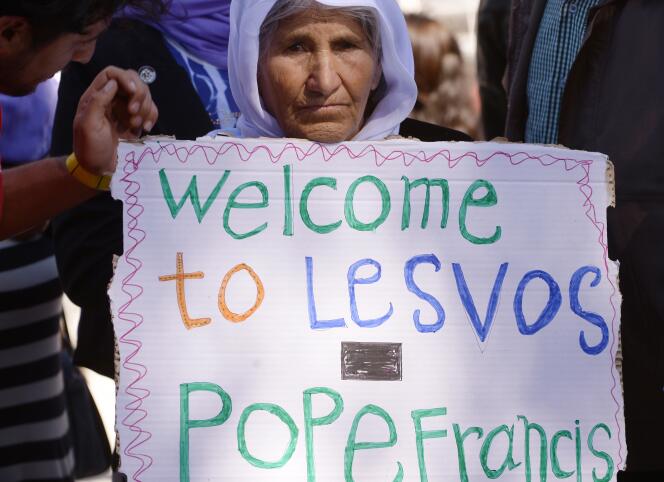 Une femme accueille le pape François avec une pancarte 