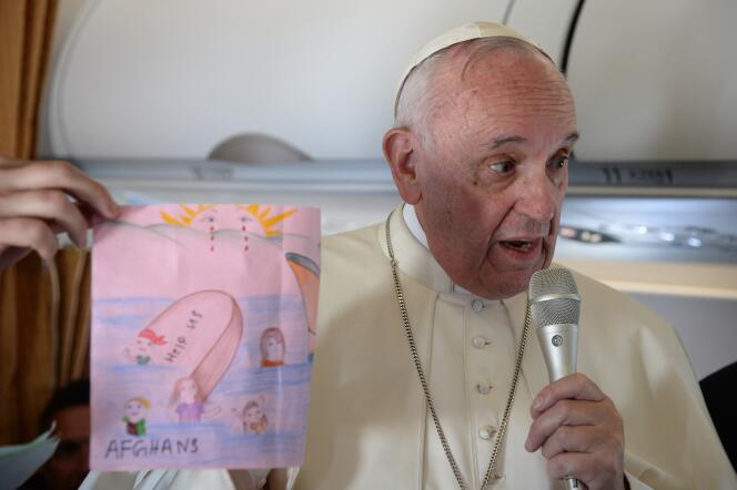 Le pape François montre un dessin réalisé par un enfant dans l'avion qui a ramené douze réfugiés syriens au Vatican.