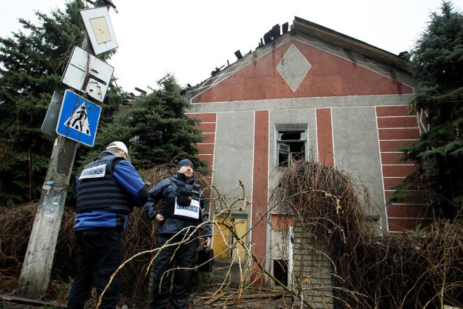 Des inspecteurs de l'Organisation pour la sécurité et la coopération en Europe (OSCE) près d'une maison détruite par un bombardement à Donetsk, en Ukraine, le 24 mars 2016.