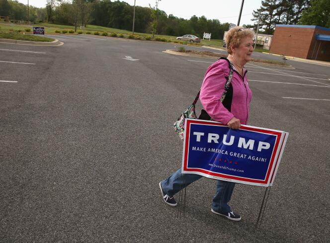 Une habitante de Mechanicsville, dans l'Etat du Maryland, emporte une affiche de campagne de Donald Trump après avoir voté, mardi 26 avril.
