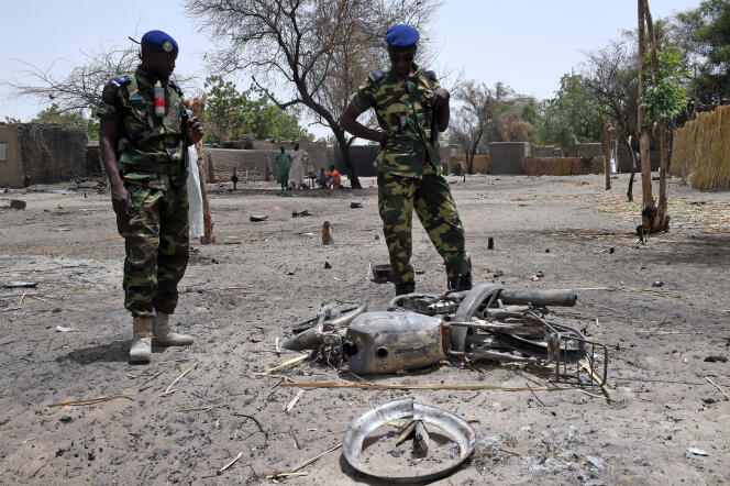 Des gendarmes tchadiens  examinent une moto détruite à N'Gouboua, dans les environs du lac Tchad, le 6 avril 2015.