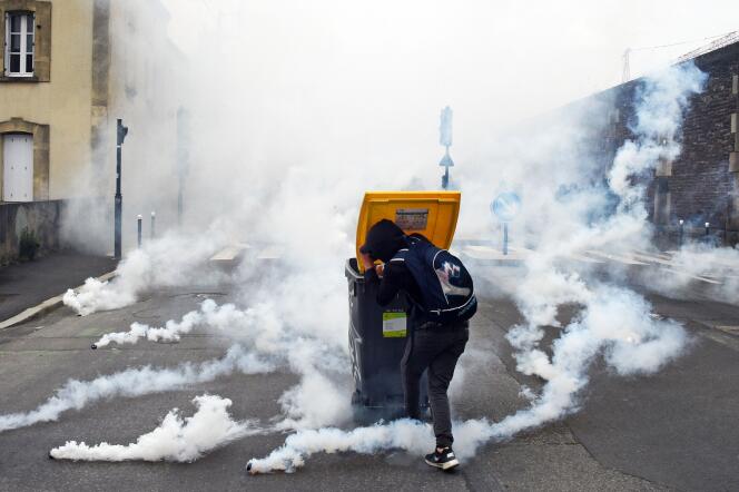 Un manifestant se protège des tirs de grenades lacrymogènes lors du rassemblement contre la loi travail à Rennes, le 17 mai.