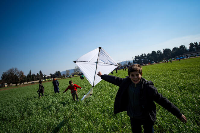 Des enfants jouent dans un champ, à proximité du camp de réfugiés d’Idomeni, à la frontière gréco-macédonienne, le 19 mars 2016.