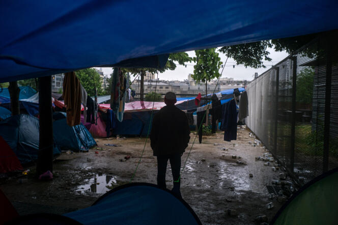 Un réfugié se tient debout dans le camp de fortune où sont installés une centaine de réfugiés dans le jardin d'Eole, à Paris, le 31 mai 2016.