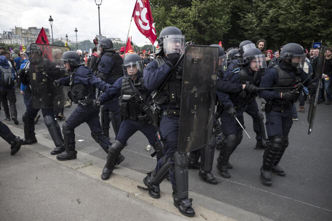 Des policiers pris à parti par des manifestants tentent de s'extirper de la foule, le 14 juin, sur l'esplanade des Invalides à Paris, lors de la manifestation contre la loi travail.