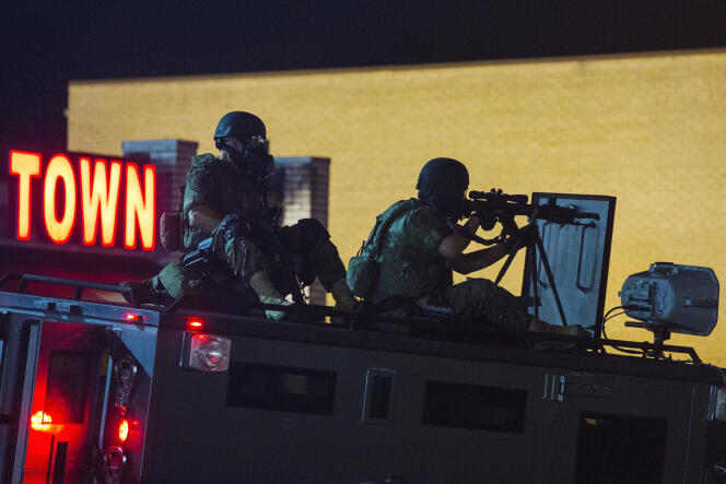 Un tireur d’élite de la police sur le toit d’un véhicule blindé de la police, lors des émeutes de Ferguson, en août 2014.