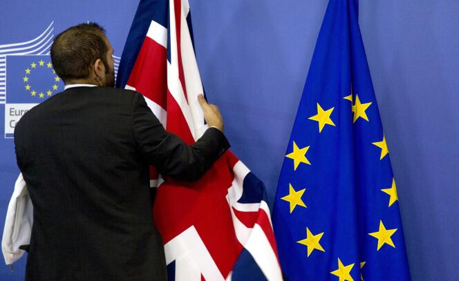 Un membre du protocole ajuste des drapeaux européen et britannique au siège du parlement européen de Bruxelles en 2015.