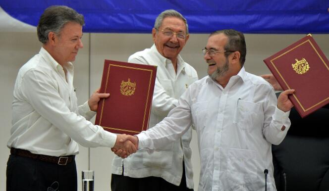 Le président colombien, Juan Manuel Santos (à gauche), et Timoleon Jimenez, alias « Timochenko », le chef de la guérilla des FARC (à droite), échangent une poignée de main sous le regard du président cubain Raul Castro, le 23 juin, à La Havane.