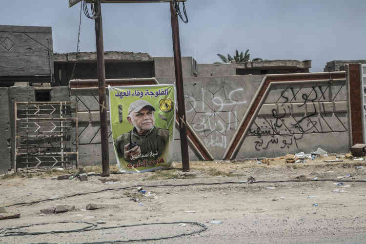 Une affiche montrant Hadi Al-Ameri, le chef de l’organisation politique et milice chiite Badr, proche de l’Iran :  « Fallouja, Nous tiendrons nos promesses. » En noir à même le mur : « Bar. 4e Brigade »