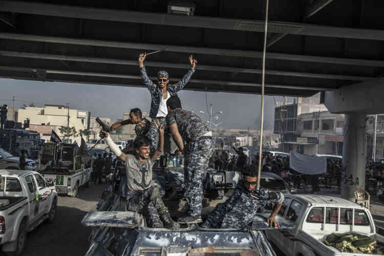 Grisés par leur victoire, les combattants de la police fédérale et des milices chiites paradent à bord de humvees et de pick-up au centre de Fallouja.