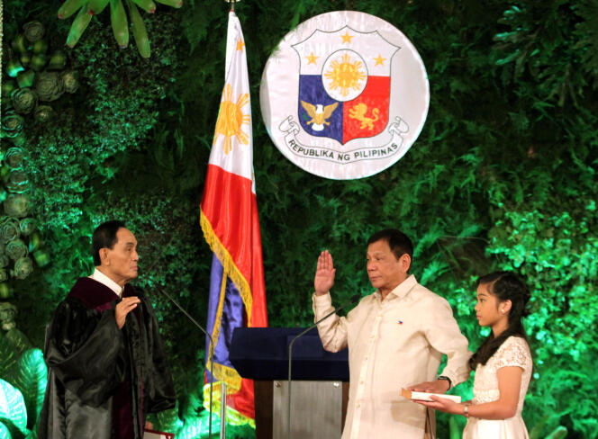 Rodrigo Duterte prête serment en tant que nouveau président des Philippines, en présence du juge de la Cour suprême Bienvenido Reyes et de sa fille Veronica, qui tient la Bible, le 30 juin, au palais de Malacanang, à Manille.