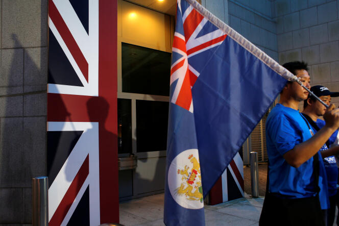 Un manifestant porte un ancien drapeau de la colonie britannique vendredi 1er juillet à Hongkong.