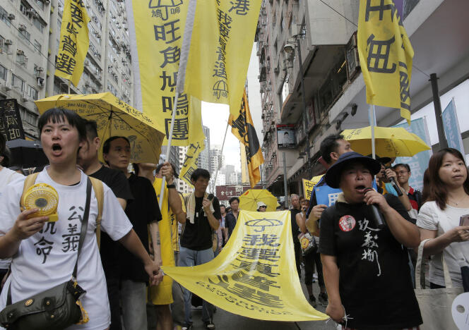 Des manifestants portant une banderole sur laquelle il est inscrit « Je veux un vrai suffrage universel », vendredi 1er juillet à Hongkong.