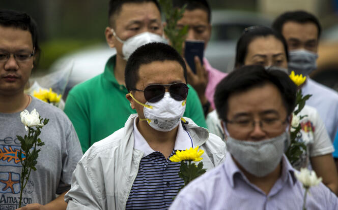 Les résidents de Tianjin portent des fleurs après l’explosion d’un entrepôt de produits chimiques, le 18 août 2015, en Chine.