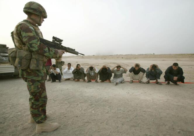 Un soldat britannique surveille des citoyens irakiens près de Bassorah, le 24 mars 2003.