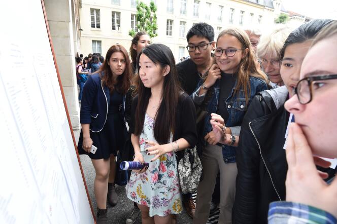 Des lycéens regardent les résultats du bac devant le lycée Louis-le-Grand, à Paris.
