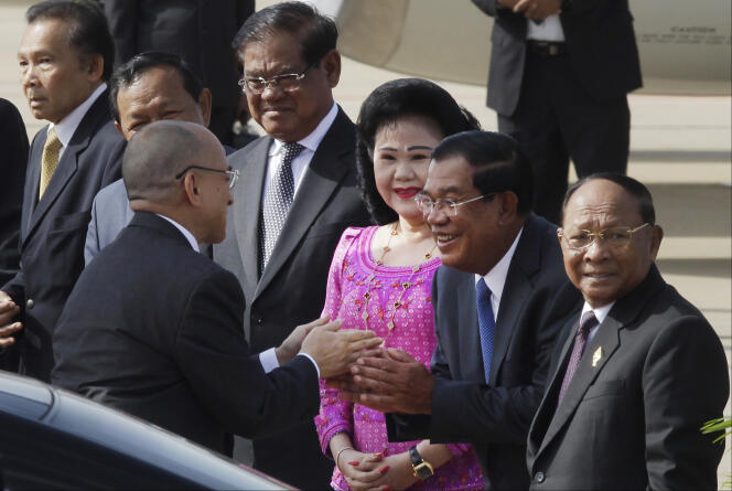 Le roi du Cambodge, Norodom Sihamoni (à gauche), est salué par le premier ministre, Hun Sen (deuxième en partant de la droite), et son épouse, Bun Rany, à l’aéroport international de Phnom Penh, le 5 juillet 2016.