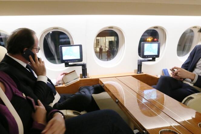 Sur cette photo publiée par l’Elysée, François Hollande s’entretient avec Manuel Valls dans l’avion qui le ramène à Paris.