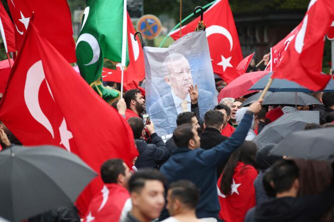 Des membres de la communauté turque à Hambourg en Allemagne, le 16 juillet 2016, brandissent des drapeaux et le portrait du président Erdogan face au consulat, en guise de protestation contre le coup d’Etat militaire.