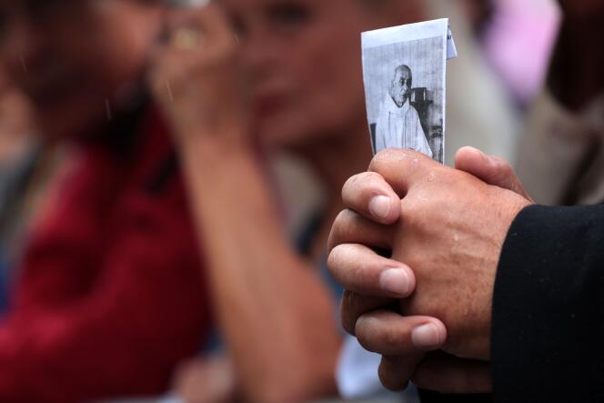 Un homme tient une photographie du père Hamel lors de ses obsèques à la cathédrale de Rouen, le 2 août.