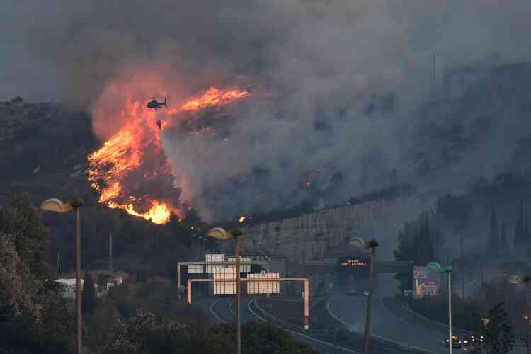 Un hélicoptère bombardier d’eau au dessus de l’incendie près l’autoroute A7 en fin de journée le 10 août.
