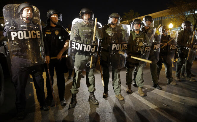 Dans les rues de Baltimore, la police s’apprête à faire respecter le couvre-feu mis en place à cause des protestations contre la violence policière, le 29 avril 2015. AP Photo/Patrick Semansky