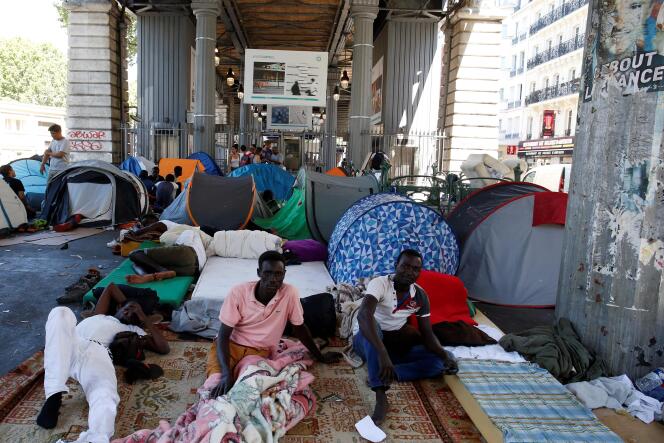 Des migrants dans un camp improvisé sous le métro aérien, à Paris, le 19 juillet 2016.