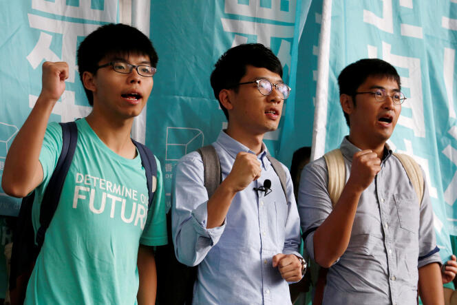 De gauche à droite, le 15 août 2016, les dirigeants étudiants Joshua Wong, Nathan Law et Alex Chow  lancent des slogans avant le prononcé du verdict, dans un procès où ils sont accusés d’incitation et de participation à un rassemblement illégal, lors du « mouvement des parapluies » en 2014.