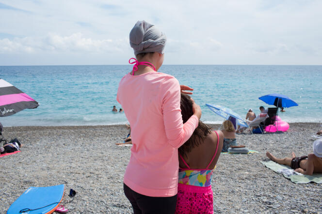 Une jeune maman et sa fille sur la plage de Nice. Elle explique que lorsqu'elle se baigne, elle se baigne dans cette tenue, une version contemporaine : leggins, tee-shirt et voile noué sur la tête.
