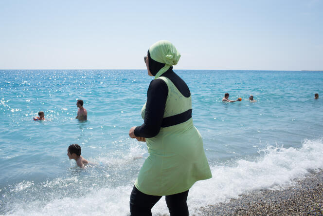 Une jeune maman portant une combinaison intégrale pour se baigner à Nice le 17 juillet 2016.