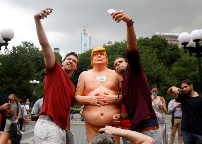 Devant une statue de Donal Trump nu, installée dans l’Union Square Park, à New York, jeudi 18 août.