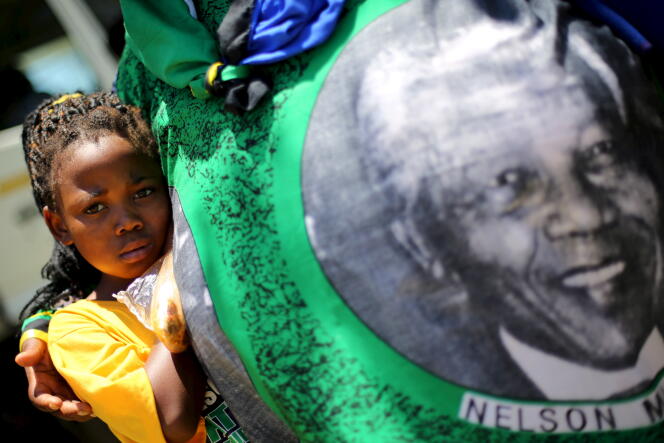 Une jeune fille regarde un pagne avec la photo de Mandela, lors du congrès de l’ANC, en janvier 2016.