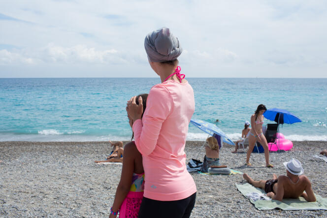 Une jeune maman et sa fille sur la plage de Nice. Elle explique que lorsqu'elle se baigne, elle se baigne dans cette tenue, une version contemporaine : leggins, t-shirt, et voile noué en chignon.