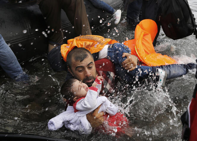 Un Syrien avec ses deux enfants tentant de débarquer après la traversée depuis la Turquie. Île de Lesbos, 24 septembre 2015.