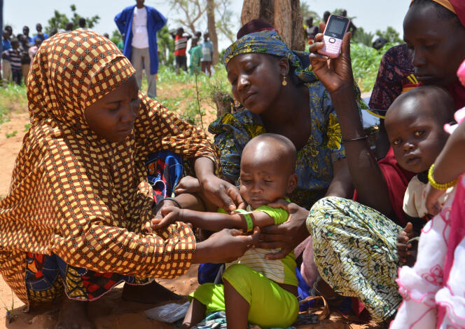 Des mères utilisent un bracelet MUAC pour lutter contre la malnutrition, dans le village de Barago, au Niger, le 14 juillet 2016.