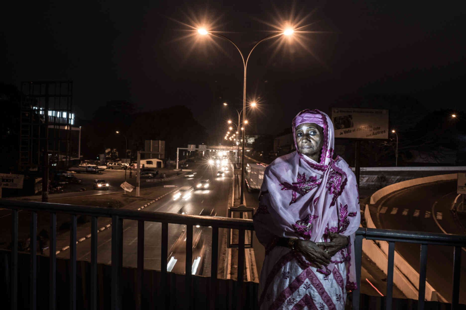 Hadja Rabi Diallo, photographiée sur le pont auquel son mari a été pendu sur les ordres du président Sékou Touré en 1971. « Mon mari s’appelait Ousmane Baldé, il était le ministre des finances. Sékou Touré l’a accusé de vouloir prendre le pouvoir. Un jour, des militaires sont venus chez nous et ont annoncé qu’il avait été arrêté. Ensuite, un de nos quatre enfants a entendu à l’école qu’il avait été pendu depuis le pont. Quand nous avons entendu la nouvelle, nous nous sommes mis à pleurer. Ils nous ont mis à la porte de notre maison et ont volé tout ce qu’ils ont trouvé. »