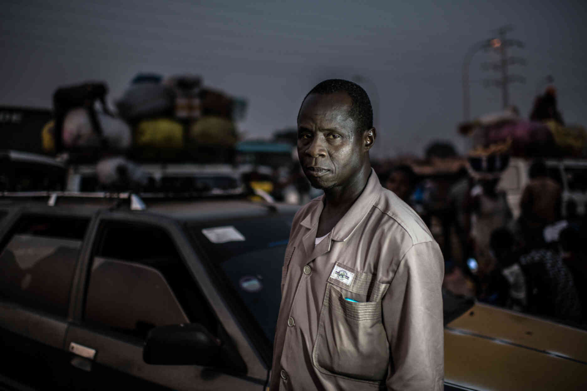 Oumar Sow, au parking de taxis de Madina, où son frère a été tué par balle par les forces de sécurité en 2007. « C’était au moment de la grève générale en Guinée. Tout d’un coup, un groupe de militaires est arrivé sur le pont au-dessus du parking et a commencé à tirer. Mon frère a reçu une balle dans le cou, il est mort. »