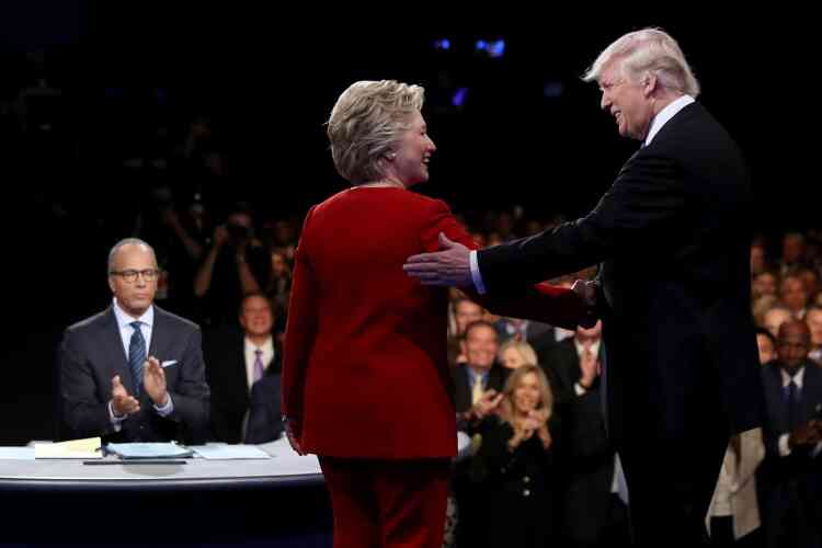 Hillary Clinton et Donald Trump accueillis par le modérateur Lester Holt. L’ex-secrétaire d’Etat arrivait au débat avec une avance réduite dans les intentions de vote, tandis que le milliardaire jouissait de sondages encourageants.