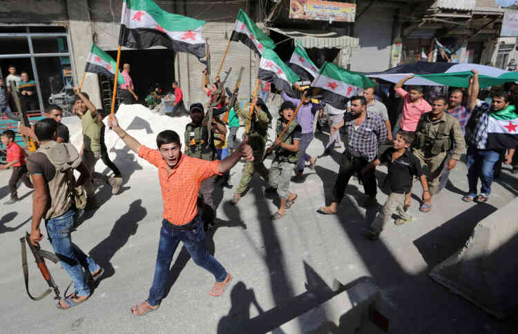 Des civils et des combattants rebelles manifestent leur solidarité avec l’Armée syrienne libre et la population d’Alep, dans la ville d’Azaz, le 27 septembre.