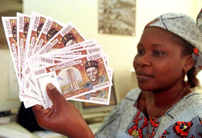 Une femme échange des billets de 10 000 FCFA (15 euros), à Abidjan, Côte d’Ivoire.