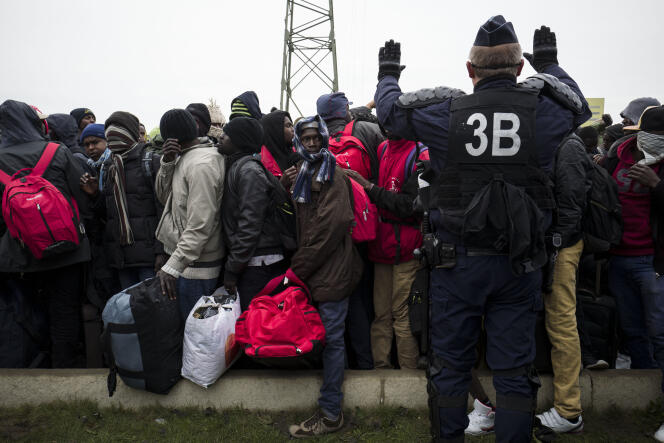 Des centaines de réfugiés attendent de monter dans l'un des bus qui les emmènera vers un centre d'accueil et d'orientation (CAO), le 24 octobre 2016 aux abords de la «  jungle » à Calais.