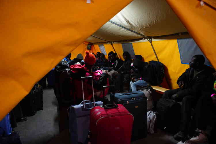 Le 24 octobre, les migrants qui ont décidé de partir de la « jungle » attendent sous une tente le bus qui les mènera vers un centre d’accueil et d’orientation.