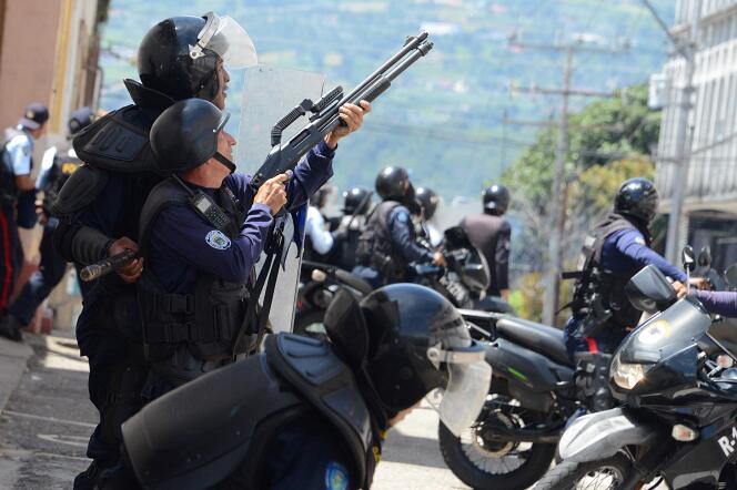 Un membre de la police anti-émeute tire en l’air lors d’une manifestation d’étudiants opposés à la politique du président Nicolas Muduro et de son gouvernement.  A San Cristobal, capitale de l’Etat de Tachira au nord-ouest du Venezuela, près de la frontière avec la Colombie, le lundi 24 octobre.