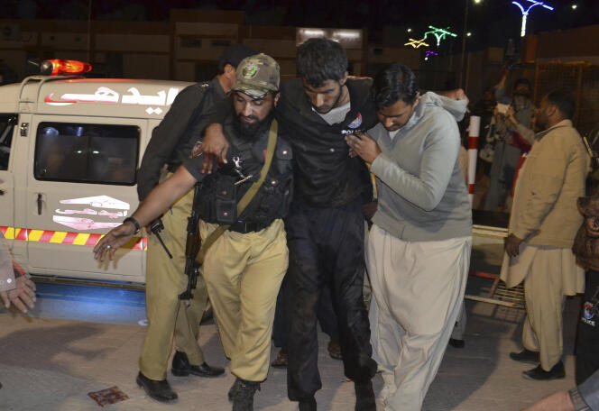 Un volontaire et un policier évacuent un blessé vers l’hôpital, à Quetta, le 24 octobre.