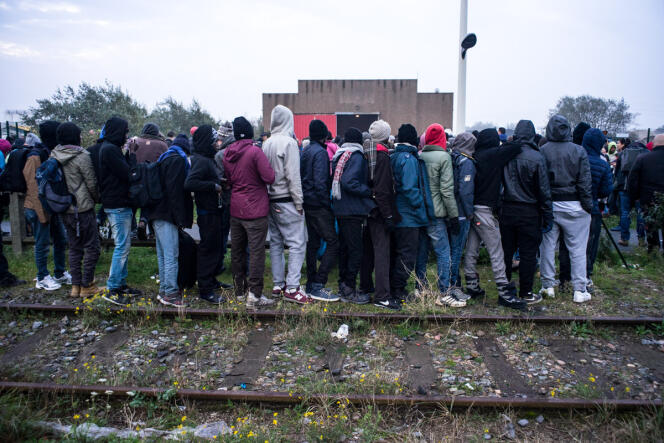 La file d'attente des mineurs isolés déborde jusque sur les vieux rails SNCF, lundi 24 octobre, au premier jour de l'opération de démantèlement de la « jungle » de Calais.