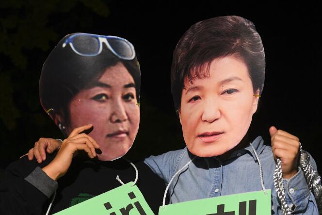 Des manifestants arborent des masques de la présidente sud-corénne, Park Geun-Hye (à droite) et de sa confidente,  Choi Soon-sil, à Séoul, le 27 octobre.