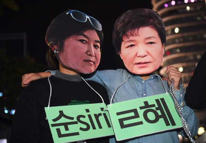 Des manifestants portent des masques figurant Choi Soon-sil et la présidente Park Geun-hye, à Séoul, le 27 octobre.