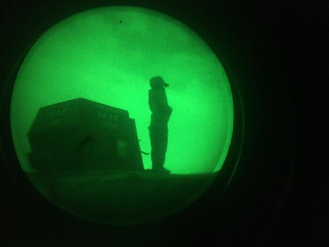 Un soldat des forces irakienne en observation sur un tank, vu d’une lunette de vision nocturne.